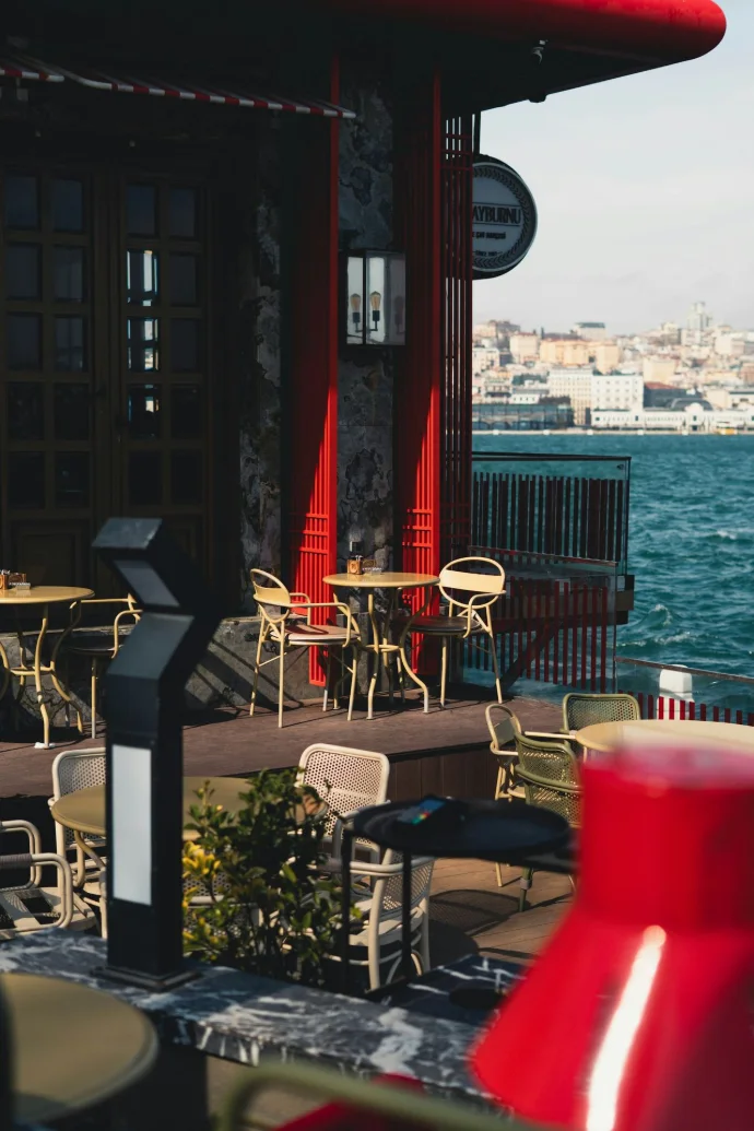 Outdoor cafe seating by the water with city skyline