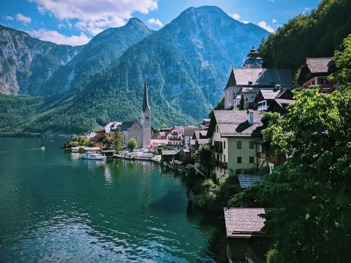 houses near body of water and mountain during daytime