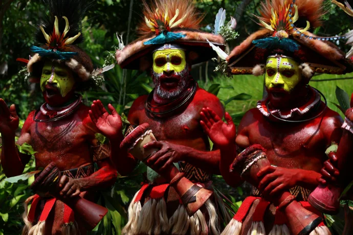 Three men in traditional tribal costumes with face paint